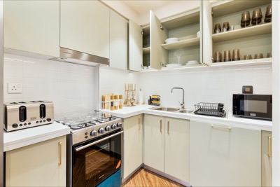 Fully equipped sage-green kitchen with full-size appliances